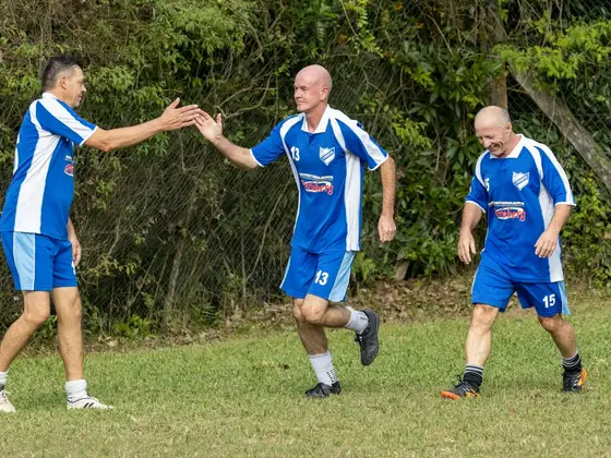 Drie oudere voetballers geven elkaar een high five